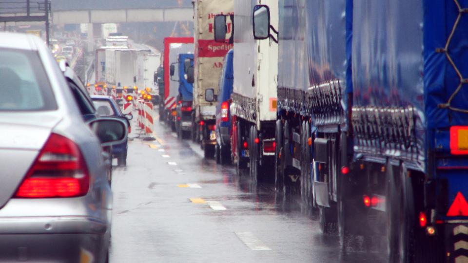 Lastkraftwagen und PKW im Stau auf der Autobahn.