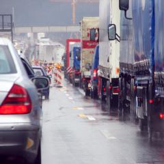 Lastkraftwagen und PKW im Stau auf der Autobahn.
